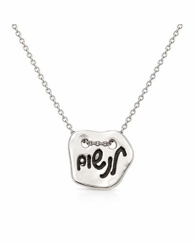 An irregular silver pendant engraved with the handwritten Hebrew word “לנשום” (“to breathe”), on a fine silver chain.
