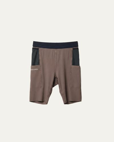 Brown 7.5-inch running tights with a black waistband and black mesh side pockets, laid flat on a cream background.